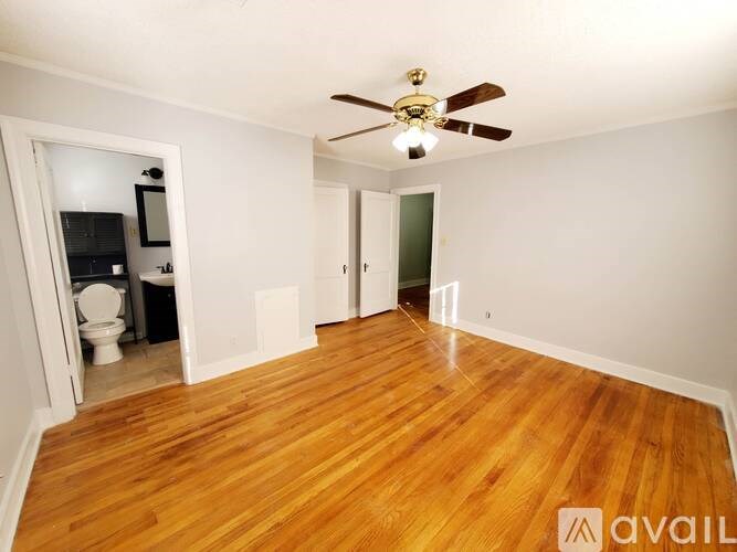 A room with wooden floors and a ceiling fan.