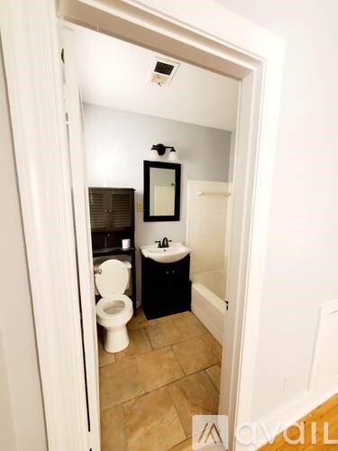 A bathroom with a toilet and a mirror.