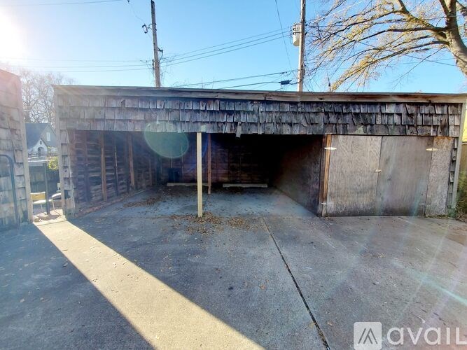 A large, empty garage with a wooden roof and concrete floor.