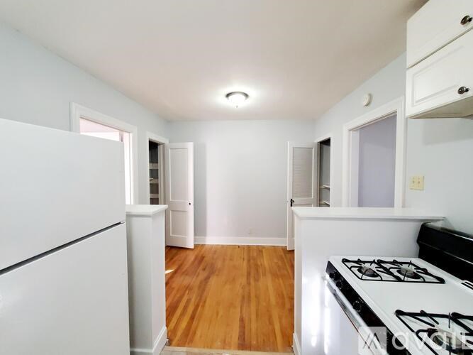 A kitchen with a white fridge, stove, and cabinets.