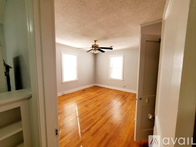 A room with wooden floors and a ceiling fan.