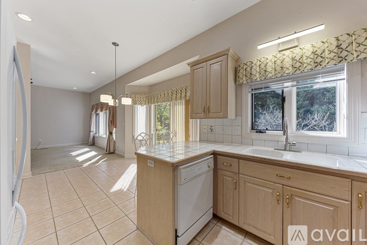 A kitchen with wooden cabinets and a white dishwasher.