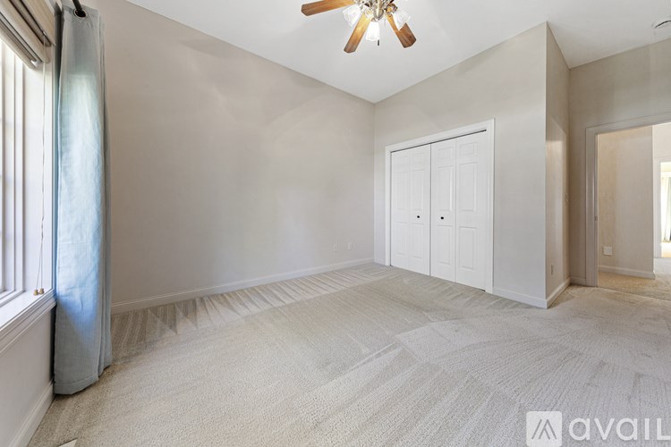 A room with a ceiling fan and a carpeted floor.
