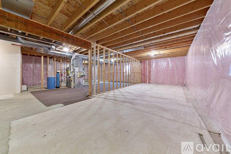 A room under construction with wooden beams and insulation on the walls.
