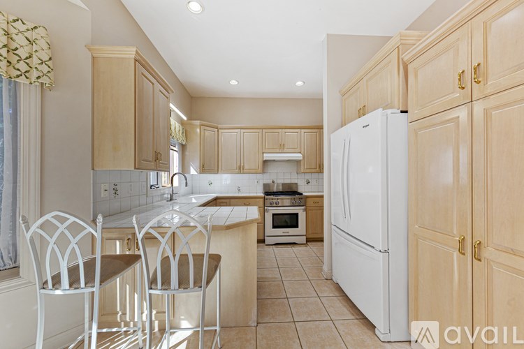 A kitchen with wooden cabinets and a white refrigerator.