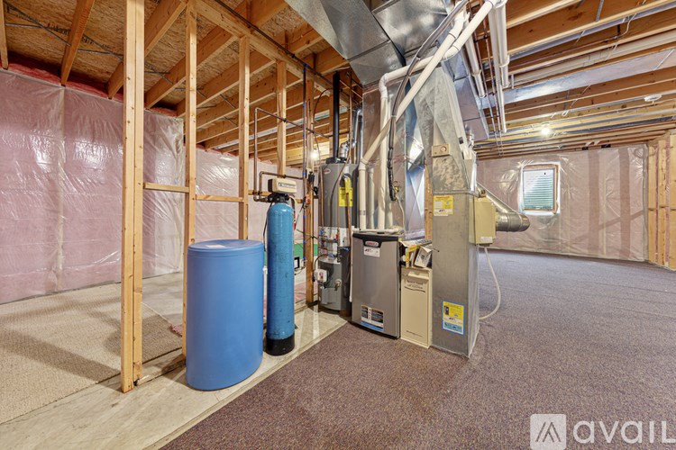 A room under construction with a blue barrel and a furnace.