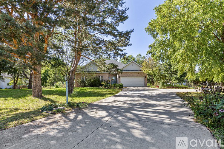 A house with a driveway and trees in front of it.