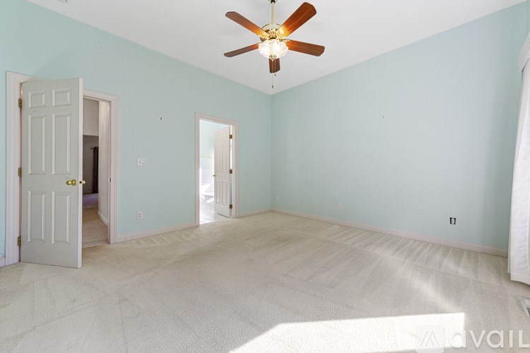 A room with a ceiling fan and two doors.