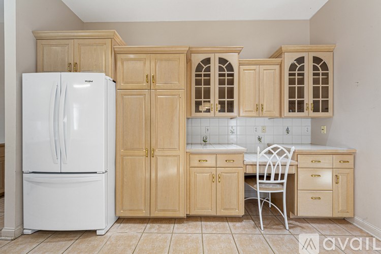 A kitchen with wooden cabinets and a white refrigerator.