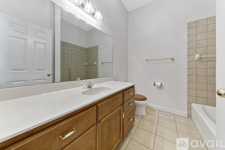 A bathroom with a white counter top and a white sink.