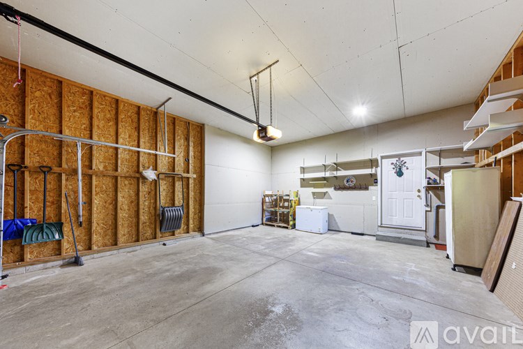 A large empty room with a white ceiling and a white door in the background.