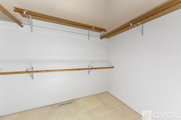 A room with a white wall and a wooden beam on the ceiling.