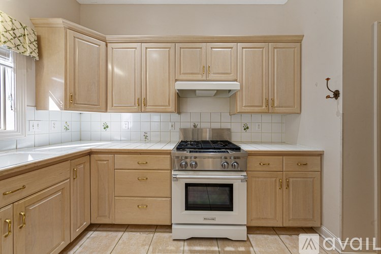 A kitchen with wooden cabinets and a white stove top oven.
