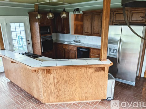 A kitchen with wooden cabinets and a large island.