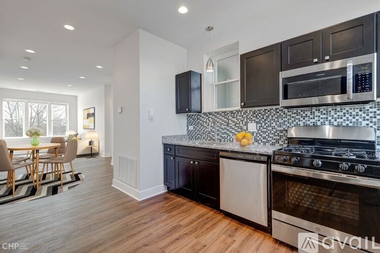 A kitchen with black cabinets and a stove top oven.
