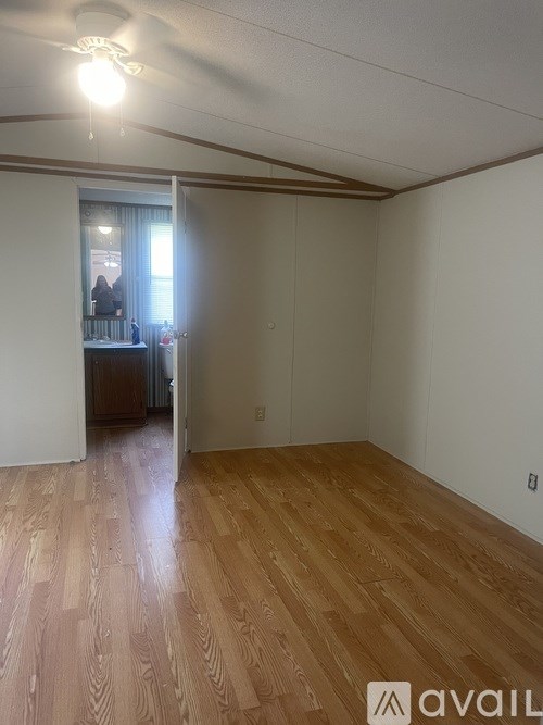 A room with wooden flooring and a ceiling fan.