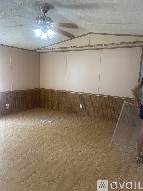 A room with wooden flooring and a ceiling fan.