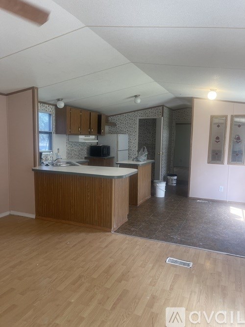 A kitchen with wooden floors and a counter.