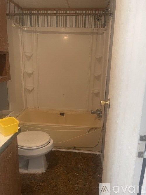 A bathroom with a toilet, tub, and a white door.