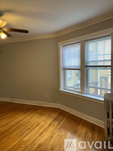 A room with a window and a fan on the ceiling.