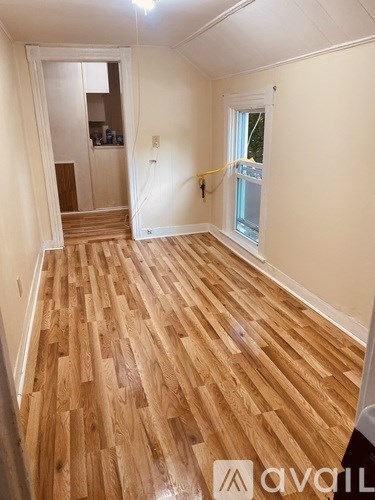 A room with wooden flooring and a window.