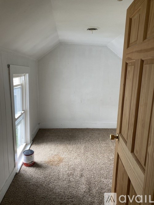 A room with a carpet and a door.