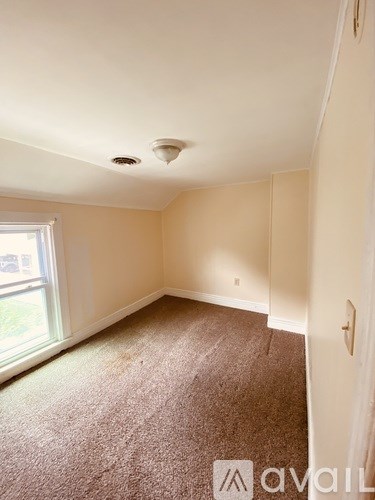 A room with a carpeted floor and a window.