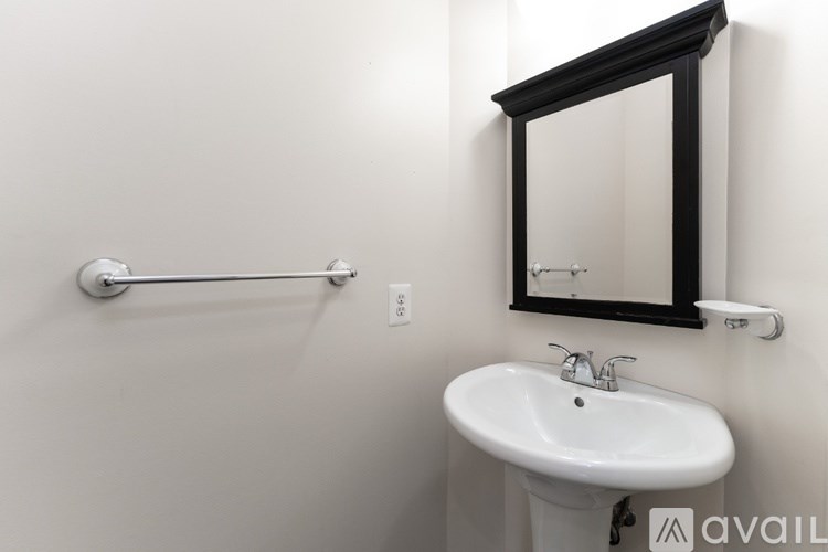 A bathroom with a white sink and a mirror above it.