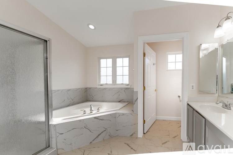 A bathroom with a marble countertop and a walk-in shower.