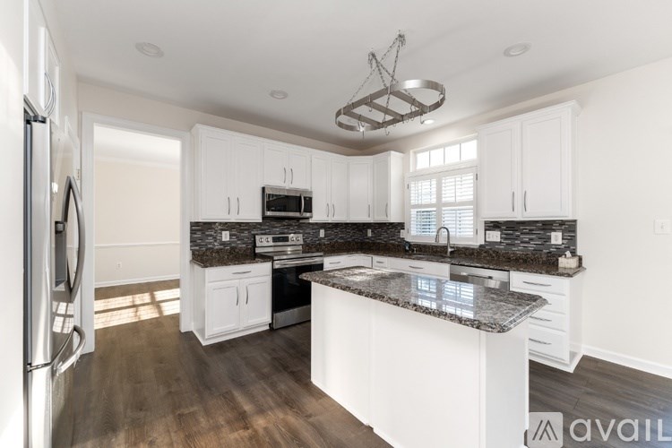 A kitchen with a granite countertop and white cabinets.