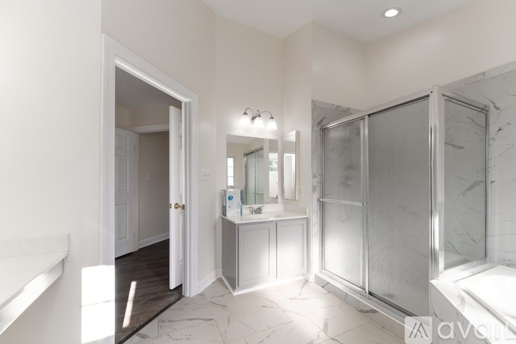A bathroom with a walk-in shower and a vanity with a mirror.
