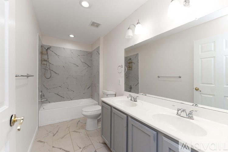 A bathroom with a marble patterned shower and a white toilet.