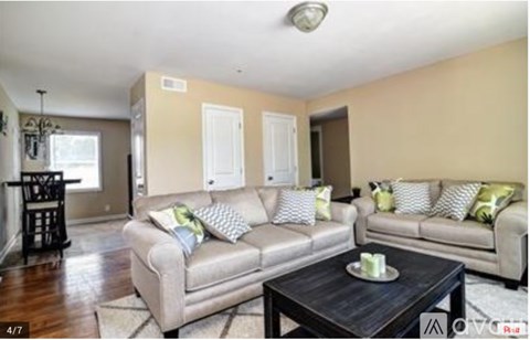 A living room with a grey couch and a black coffee table.