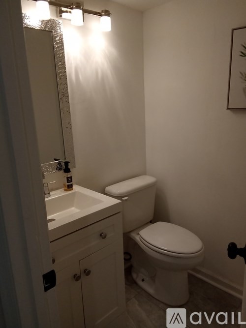 A white toilet sits next to a sink in a small bathroom.