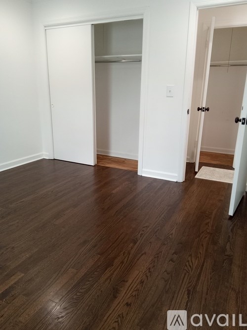 A room with a wooden floor and two white doors.