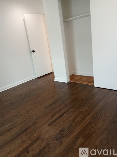 A room with wooden flooring and a white door.