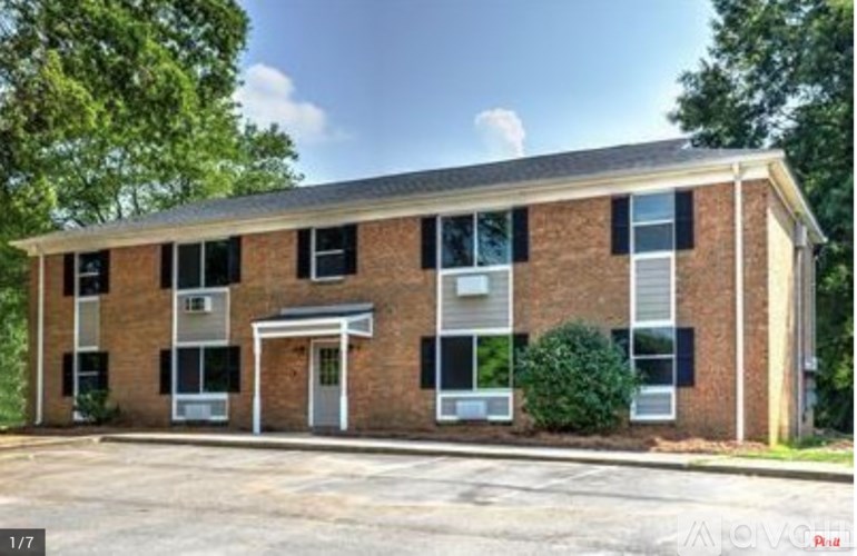 A two-story brick building with a white door and windows.
