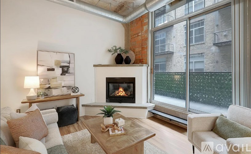 A living room with a fireplace and a large window.