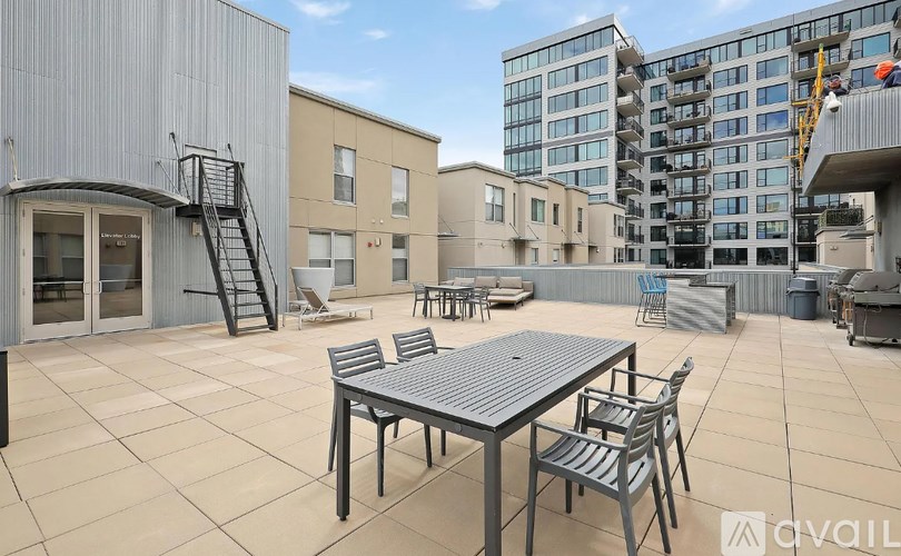 A patio with a table and chairs is in front of a building.