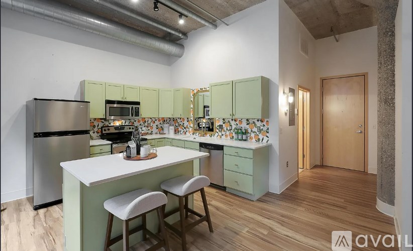 A kitchen with a white countertop and green cabinets.