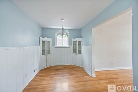 A room with a chandelier and a window with a view of a building.
