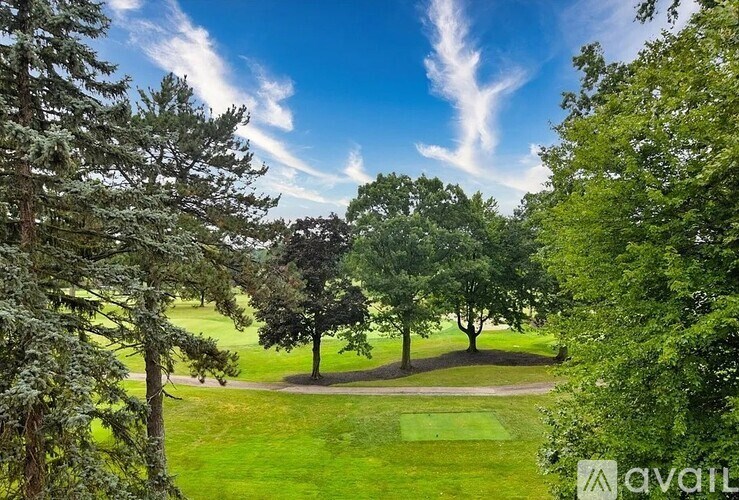 A lush green landscape with trees and a clear blue sky.