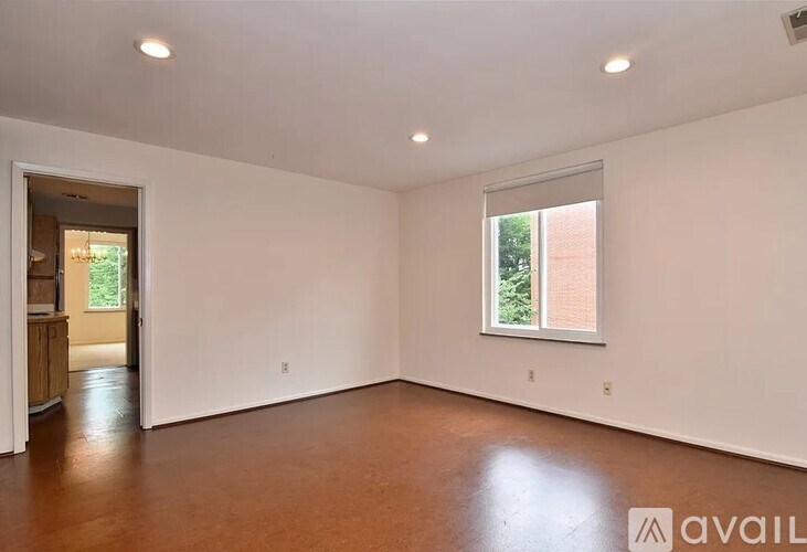 A spacious room with a window and a door leading to another room.