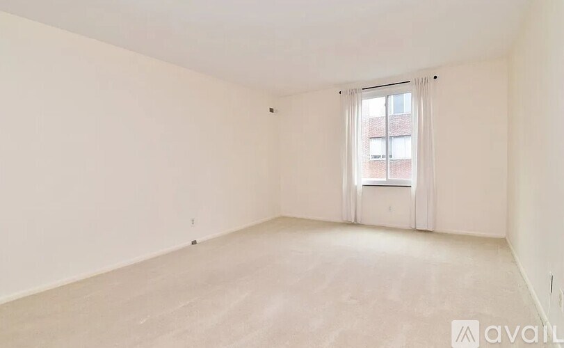 A large empty room with a window and a door.