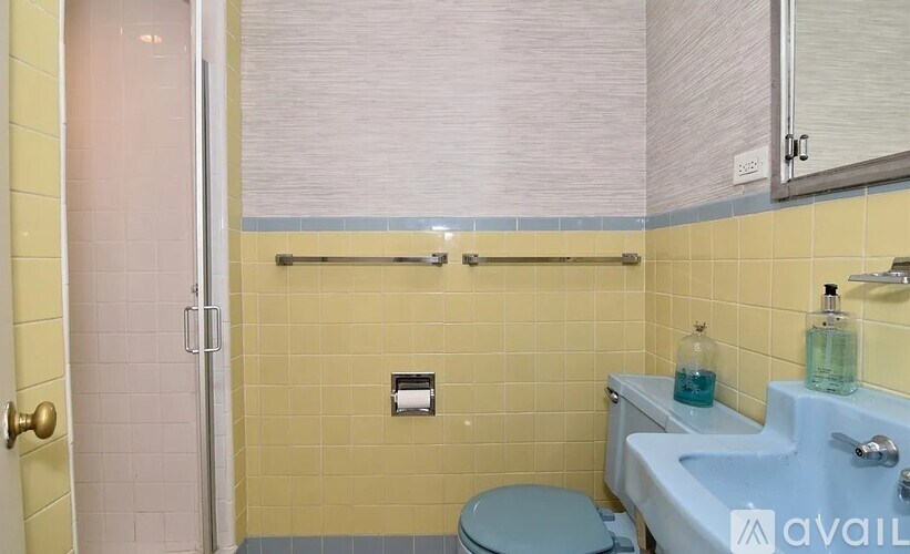 A bathroom with a toilet, sink, and shower.