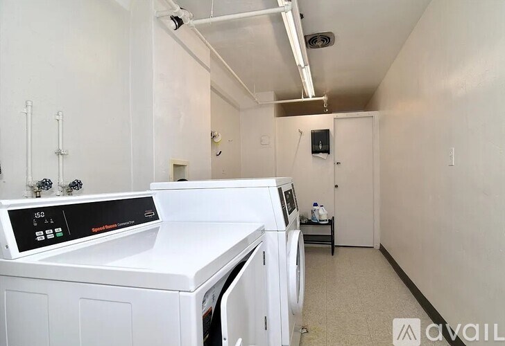 A white washing machine is in a small laundry room.