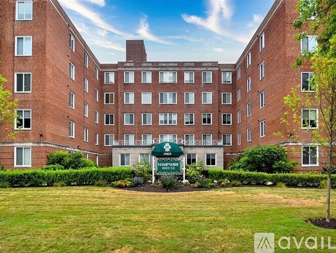 A large brick building with a green sign in front that says "Available".