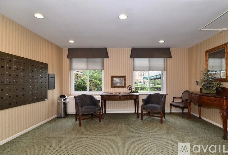 A room with a desk, chairs, and a bulletin board on the wall.