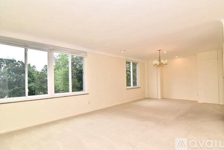 A spacious room with a chandelier and large windows.