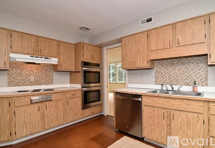 A kitchen with wooden cabinets and a checkered backsplash.